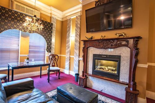 a living room with a fireplace and a tv at The Anniversary Inn - Boise in Boise