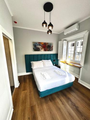 a bedroom with a large bed with a blue headboard at Relax and Explore Lisbon Suites and Rooms in Lisbon