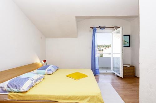 ein Schlafzimmer mit einem gelben Bett und einem Fenster in der Unterkunft Apartments by the sea Brodarica, Sibenik - 466 in Brodarica