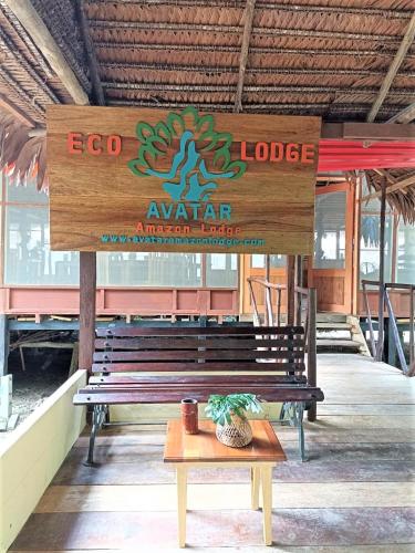 a wooden bench in a building with a sign at Avatar Amazon Lodge & Canopy Park in Santa Teresa
