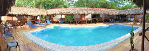 a swimming pool at a resort with chairs and a building at Avatar Amazon Lodge & Canopy Park in Santa Teresa
