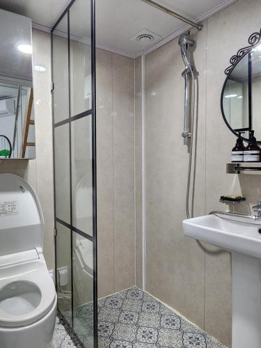 a bathroom with a shower and a toilet and a sink at Seochon Secret Cave House in Seoul