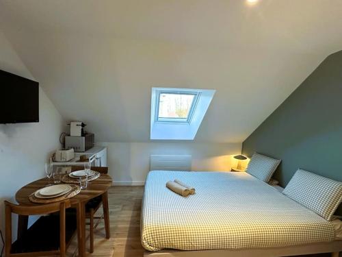 a bedroom with a bed and a table and a window at L'Esprit Vert Rivage ~Gare St ROCH ~FREE Parking in Amiens