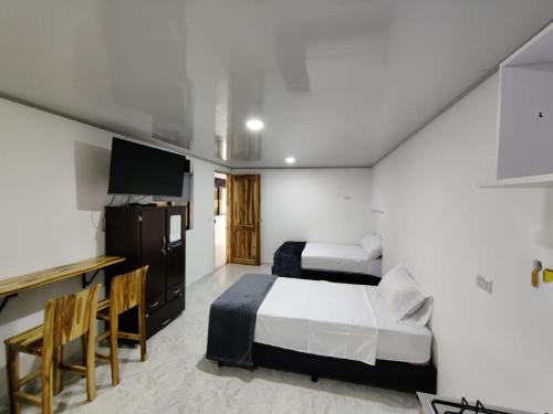 a hotel room with a bed and a desk at Apartahotel Sevilla in Medellín