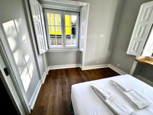 a bedroom with a white bed and a window at Relax and Explore Lisbon Suites and Rooms in Lisbon