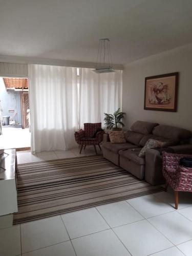 ein Wohnzimmer mit einem Sofa und einem Teppich in der Unterkunft Casa linda Praia dos Sonhos in Itanhaém