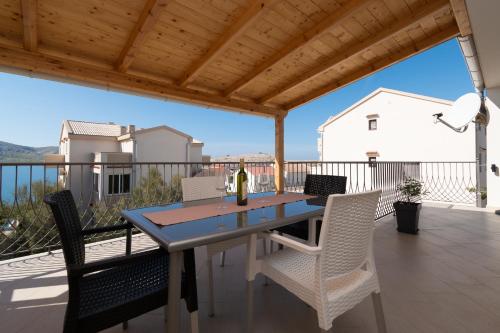 a table with chairs and a bottle of wine on a deck at Apartments by the sea Zubovici, Pag - 4141 in Zubovići