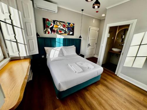 a bedroom with a bed with white sheets and pillows at Relax and Explore Lisbon Suites and Rooms in Lisbon