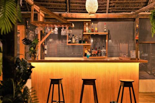 a bar with three bar stools at a bar at Avatar Amazon Lodge & Canopy Park in Santa Teresa
