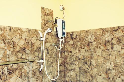 a shower in a bathroom with a phone on a wall at Sinhagiri Villa in Sigiriya