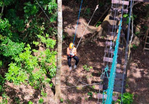 a man on a zip line in the forest at Avatar Amazon Lodge & Canopy Park in Santa Teresa