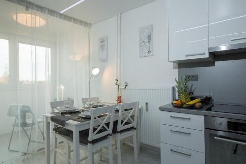 una cocina blanca con mesa y sillas. en Apartments with WiFi Velika Gorica, Prigorje - 22011, en Velika Gorica
