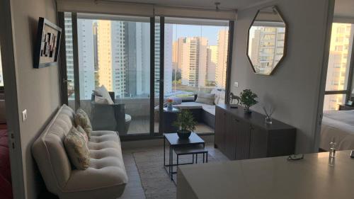 a living room with a view of a city at Hermoso y comodo Departamento con vista al mar, costas de montemar in Concón