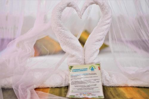 a white towel with a heart made out of it at Avatar Amazon Lodge & Canopy Park in Santa Teresa