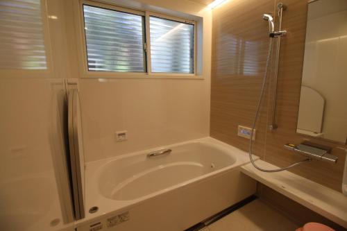 Cottage All Resort Service / Vacation STAY 8427 في Inawashiro: حمام مع حوض استحمام ونافذة