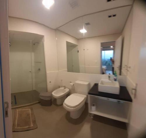 a bathroom with a toilet and a sink and a mirror at Edificio Carmelitas insuperable una habitación in Asuncion