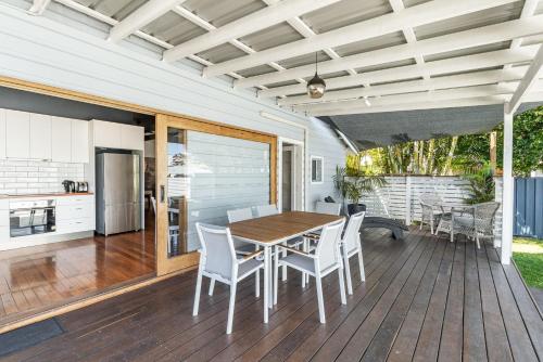 a kitchen and dining room with a wooden table and chairs at High Fives - Pet-Friendly Gem in the Heart of Yamba - Holiday Yamba in Yamba
