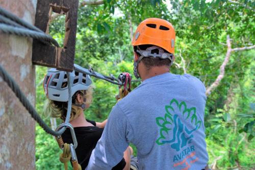 a man and a woman wearing helmets on a zip line at Avatar Amazon Lodge & Canopy Park in Santa Teresa