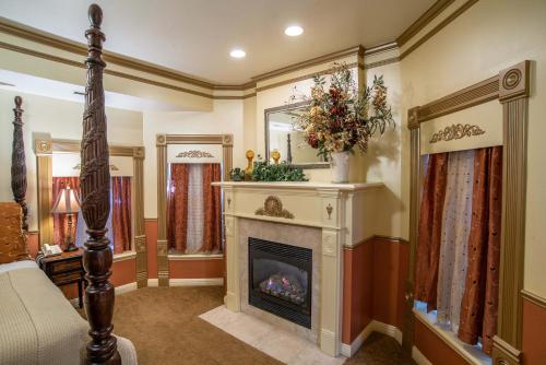 a living room with a fireplace and a mirror at The Anniversary Inn - Logan in Logan