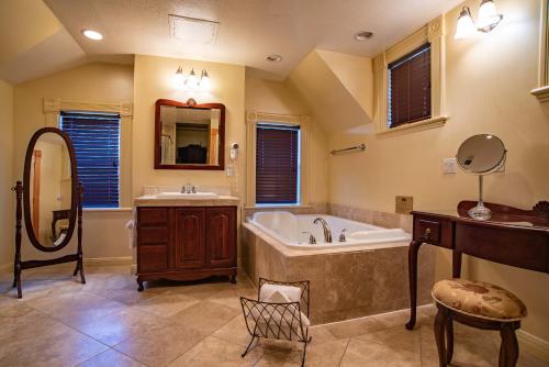 een grote badkamer met een bad en een wastafel bij The Anniversary Inn - Logan in Logan
