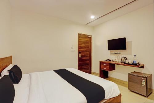 a bedroom with a bed and a desk with a television at Collection O SSR Royal Suites in Lingampalli