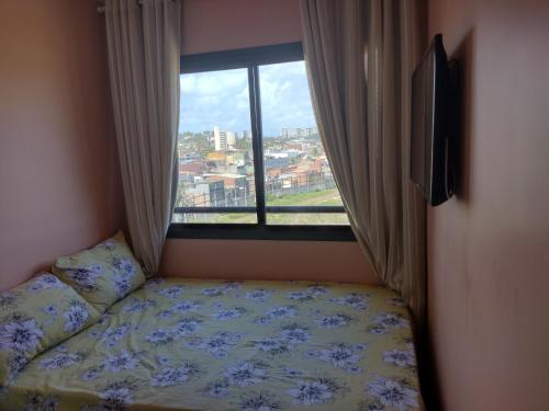 um quarto com uma cama e uma grande janela em Excelente apartamento 02 quartos frente ao mar em Salvador