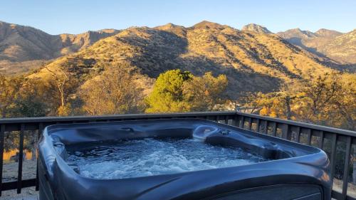 uma banheira de hidromassagem num deque com montanhas ao fundo em Mountain View, Hot Tub, Open Kitchen, 10m to Sequoia em Three Rivers