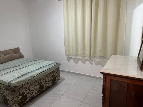 uma cama num quarto com uma janela em Casa Cantinho da Família - Praia de Guaibim - em Guaibim