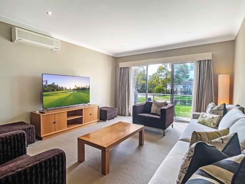 a living room with a couch and a flat screen tv at Villa Lago in Lovedale
