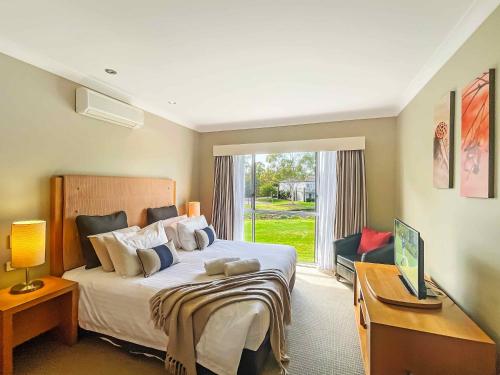 a bedroom with a bed and a desk and a window at Villa Lago in Lovedale