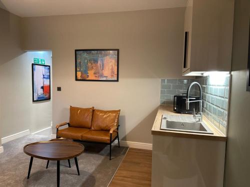 a kitchen with a sink and a table and a chair at City Centre Studios @44 by DH ApartHotels in Peterborough