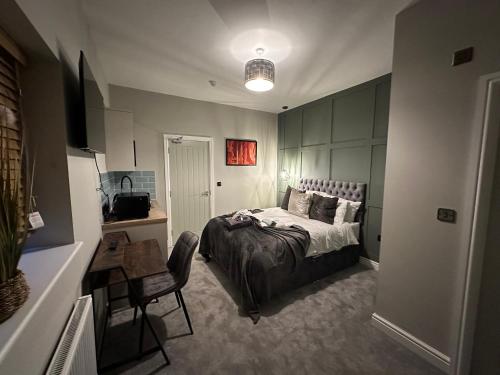 a bedroom with a bed and a desk and a chair at Studio 44 - Spacious Studios - City Centre Location - Contractor Friendly - Free WiFi - Smart TV - Desk Space - Well Designed - Communal Garden in Peterborough