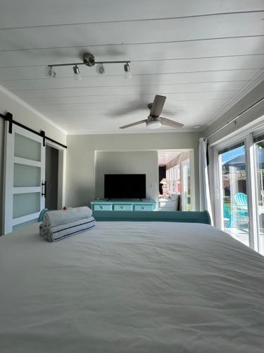 um quarto com uma cama grande e uma televisão de ecrã plano em Seashell House em Clearwater