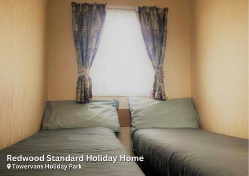 A bed or beds in a room at Redwood Standard Holiday Home