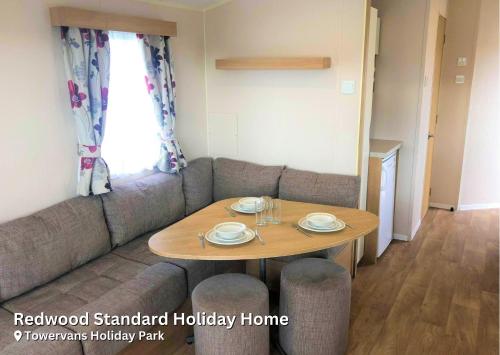 a living room with a table and a couch at Redwood Standard Holiday Home in Mablethorpe