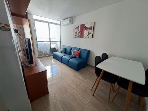 卡塔赫納的住宿－Cómodo apartamento en Cartagena，客厅配有蓝色的沙发和桌子