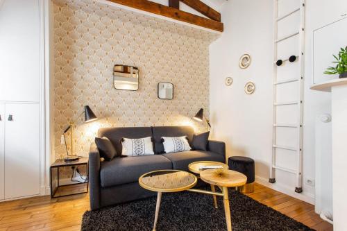 a living room with a couch and a table at Comfy studio lumineux - Trocadero Doumer 2 in Paris