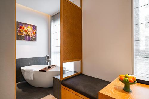 a bathroom with a tub and a sink at POKKEI Hotel Shaoxing in Shaoxing