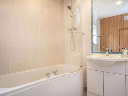 a bathroom with a bath tub and a sink at Rathad An Drobhair in Garve