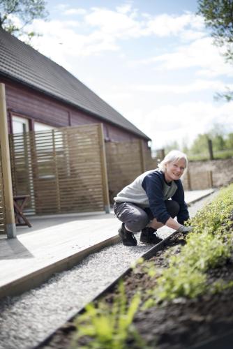 a woman kneeling on the ground in front of a house at Toftastrand Hotell in Växjö