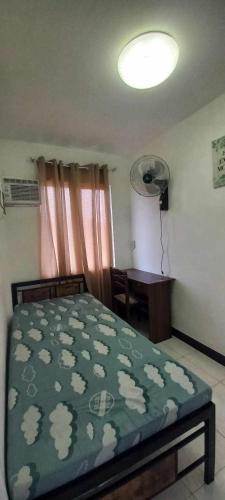 een slaapkamer met een bed met een groen dekbed bij 3-Bedroom House in Butuan