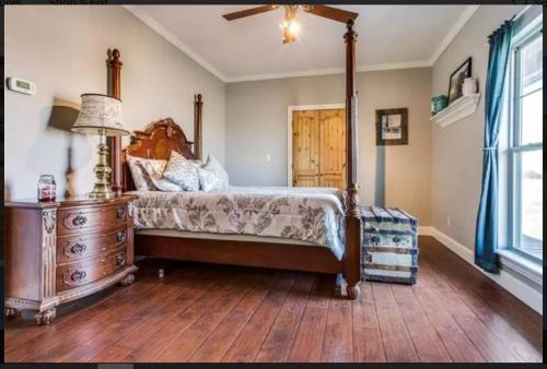 ein Schlafzimmer mit einem Himmelbett und einer Holzkommode in der Unterkunft Luxurious farm house! 5-bed, 4 bath, pool and spa. in Bonham