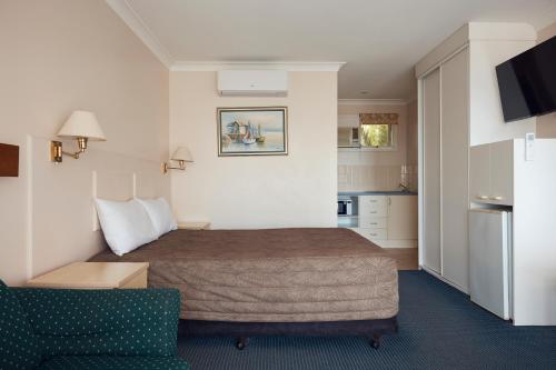um quarto de hotel com uma cama e uma cozinha em Holiday Lodge Motor Inn em Narooma