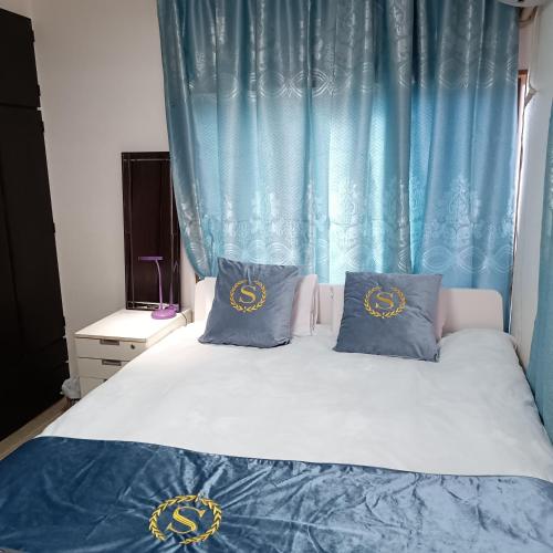 a bed with blue curtains and two pillows on it at kyoka house練馬 in Tokyo