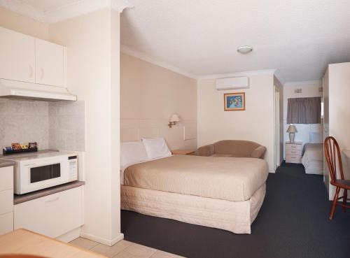 Habitación de hotel con cama y microondas en Holiday Lodge Motor Inn, en Narooma