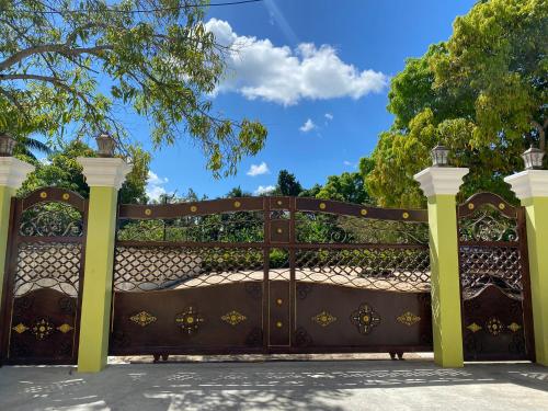 a gate in a driveway with yellow columns at Perfecto para Descansar y Desconectarse Villa Zapata - Apartamentos Turísticos in San Cristóbal