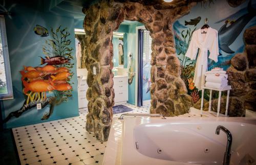 a bathroom with a large bathroom with a bath tub at The Anniversary Inn - Logan in Logan