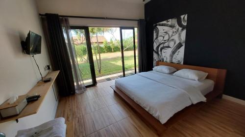 una camera con un letto e una grande finestra di Mercusuar Resort Jepara a Kesembu