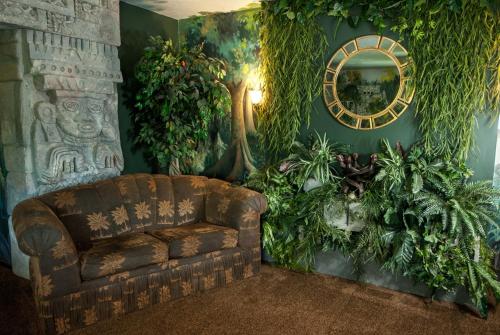 a living room with a couch and some plants at The Anniversary Inn - Logan in Logan