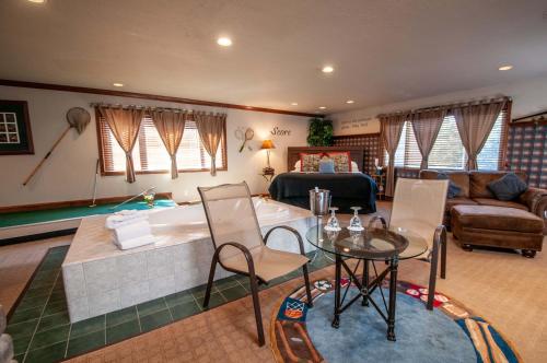 a living room with a tub and a table and chairs at The Anniversary Inn - Logan in Logan